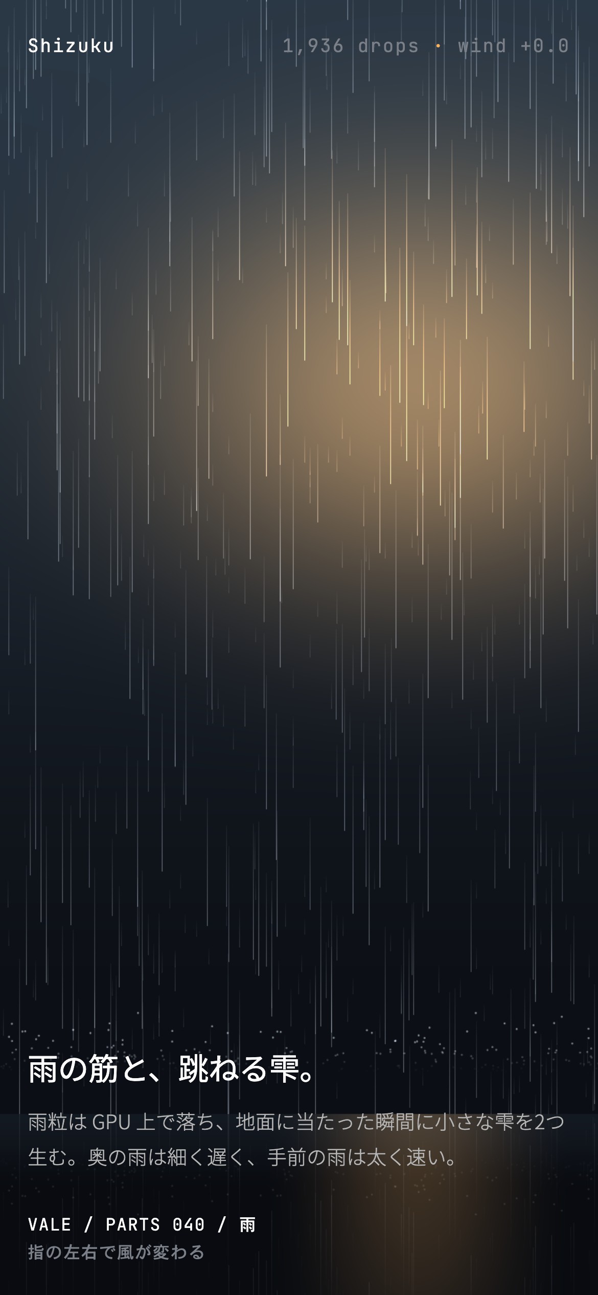夜の路上に雨の筋が降って地面で跳ね、街灯の近くだけ暖色に光る
