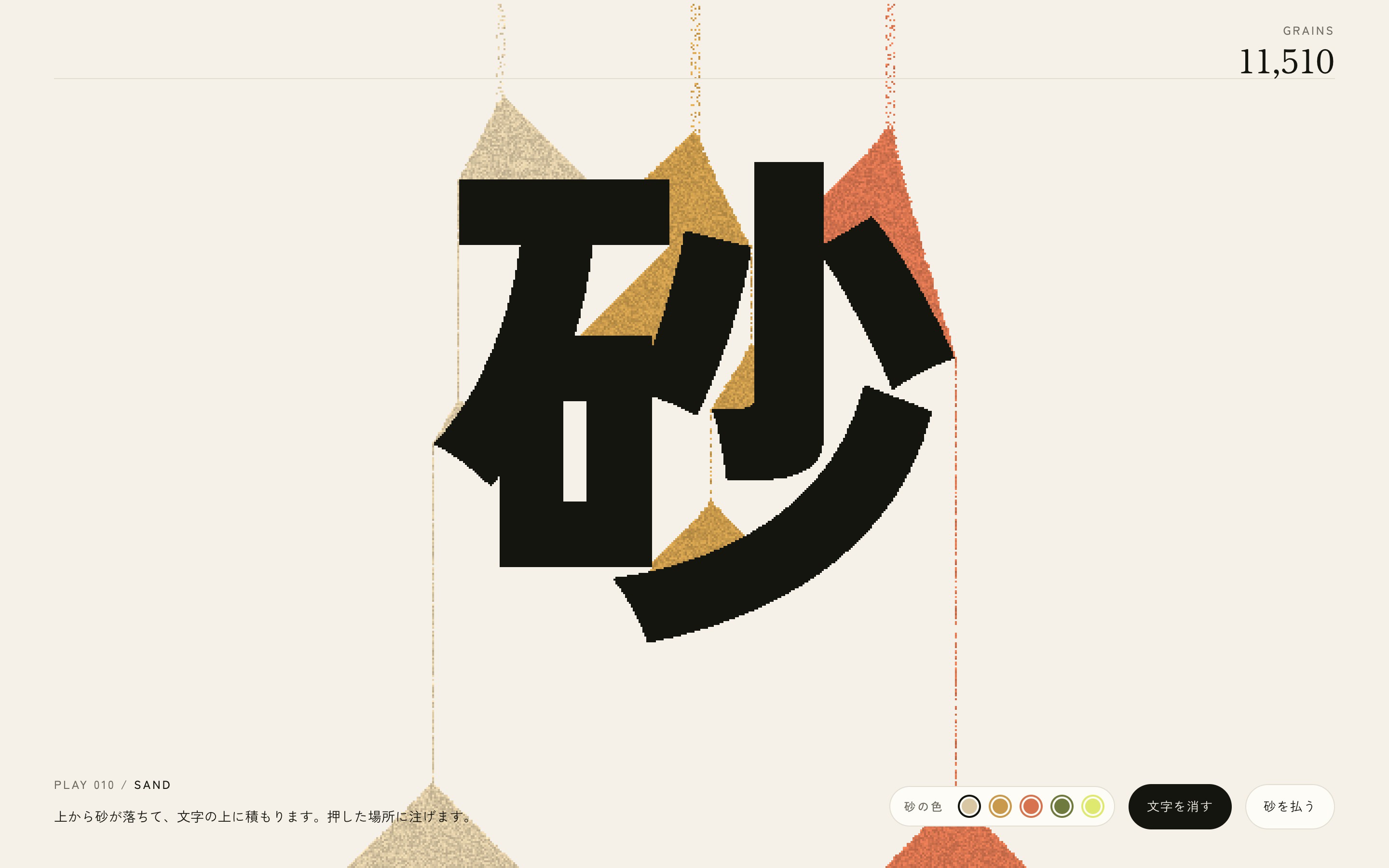 文字の上に色の砂が積もり、文字を消すと崩れる動画とPC・スマホ画面